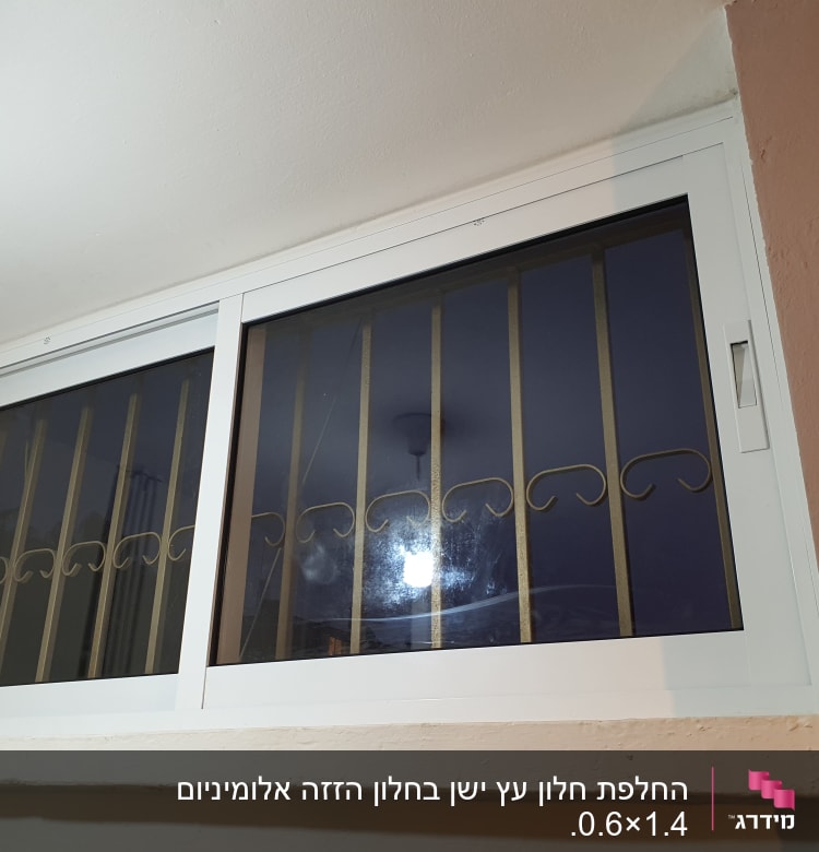 חלון אלומיניום עם מסגרת לבנה וסורגים